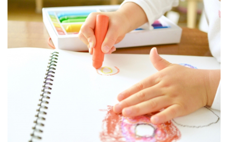 家庭でできる2歳のおうち学習として、お絵描きで色彩感覚や想像力を育む幼児の姿