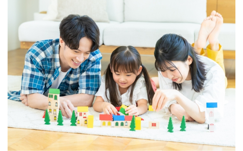 幼児が親子で積み木遊びに取り組み、聞く力や考える力を伸ばしているシーン