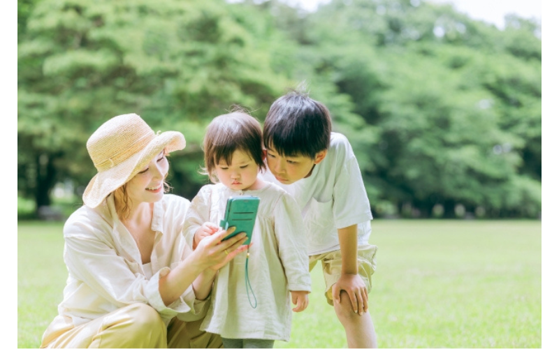 親子がスマホを見て、2歳の勉強ごっこに役立つ対処法やアイデアを調べている様子