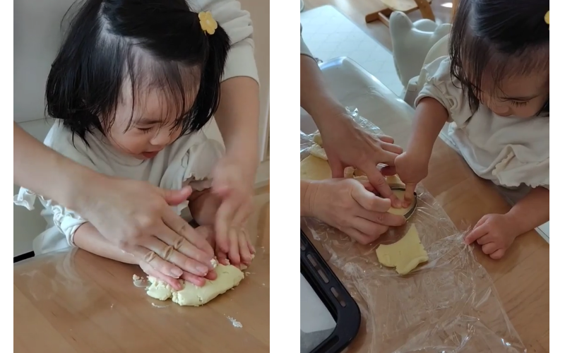 2歳児がクッキー生地をこねたり型抜きしたりしている場面