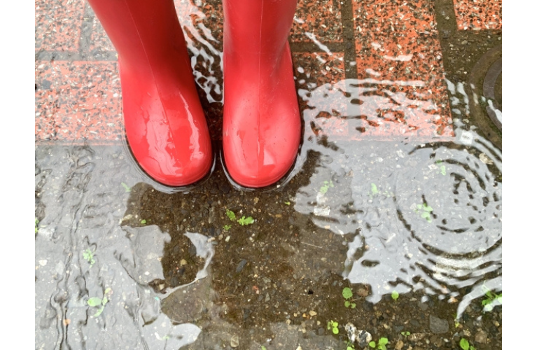 雨の中を長靴で歩く子どもの様子