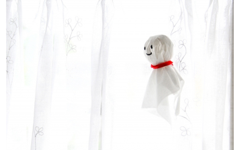 雨の日に窓辺に吊るされたテルテル坊主