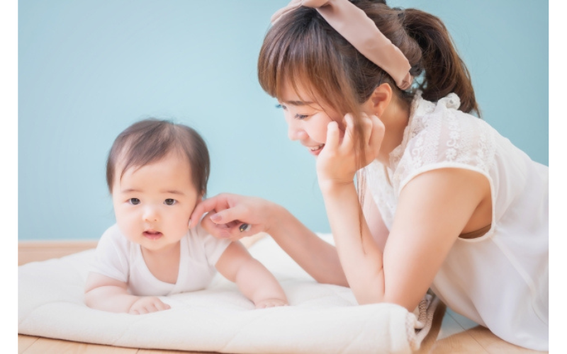 夜泣き対策をしてご機嫌に起きることができた子どもとほっとしている母親